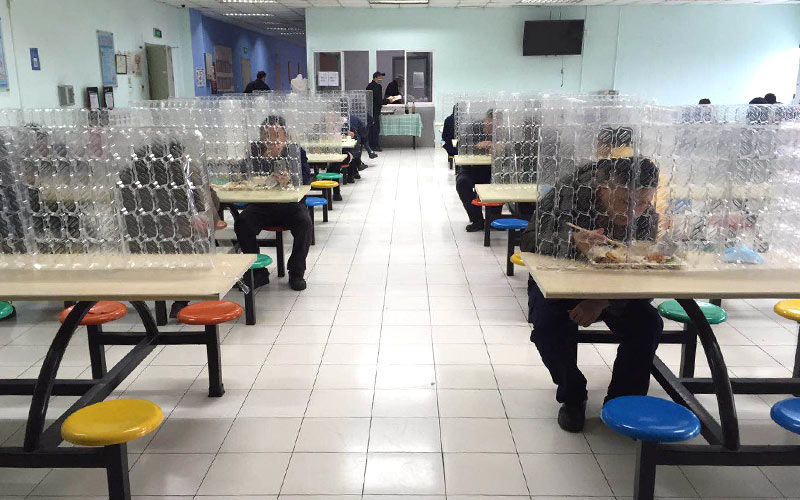 Employees have meals in the canteen with partitions installed.